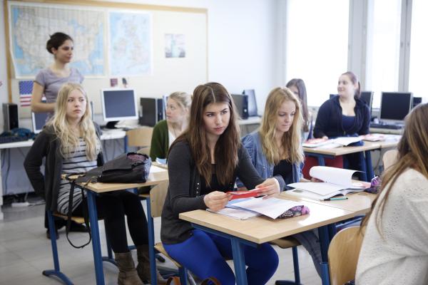 Kuvituskuva, opiskelijat kuuntelevat opettajaa.