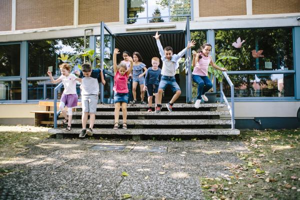 En grupp barn springer glatt ut ur skolan.
