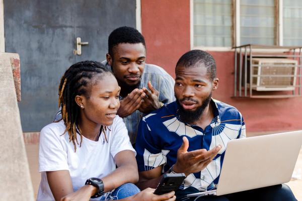 Two men and a women working together on a laptop