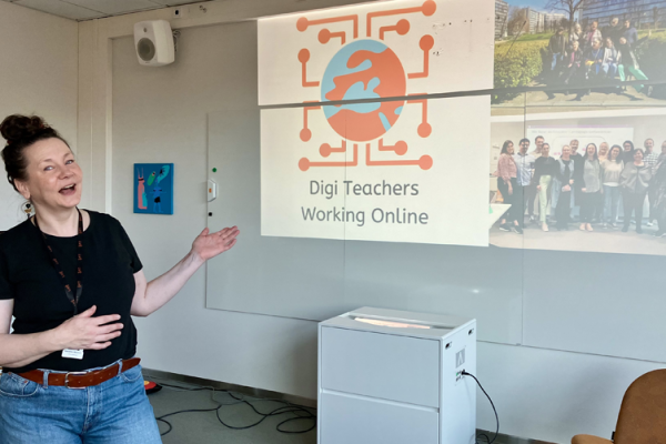 Project coordinator in front of a screen in a classroom.