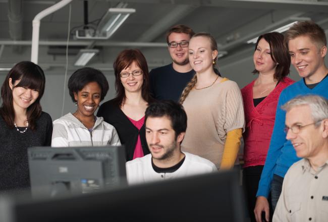 Students gathered to look at a computer screen