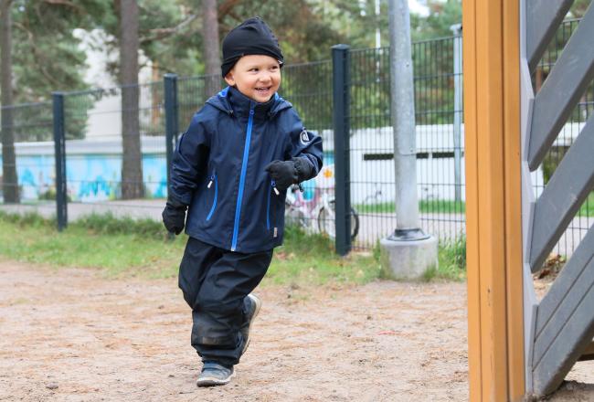 Kuvituskuva, lapsi juoksee päiväkodin pihalla