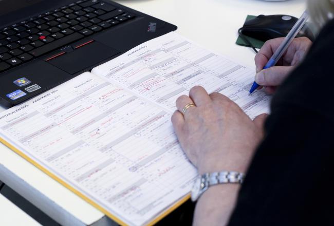 Opettaja kirjoittaa kalenteriin