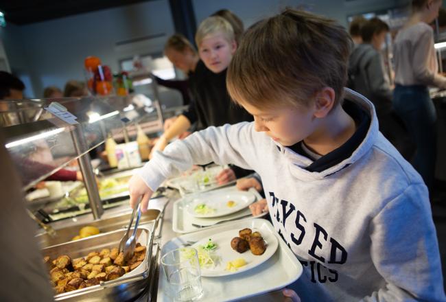 Oppilas ottaa ruokaa ruokalassa