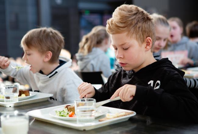 Boys eating at a cafeteria