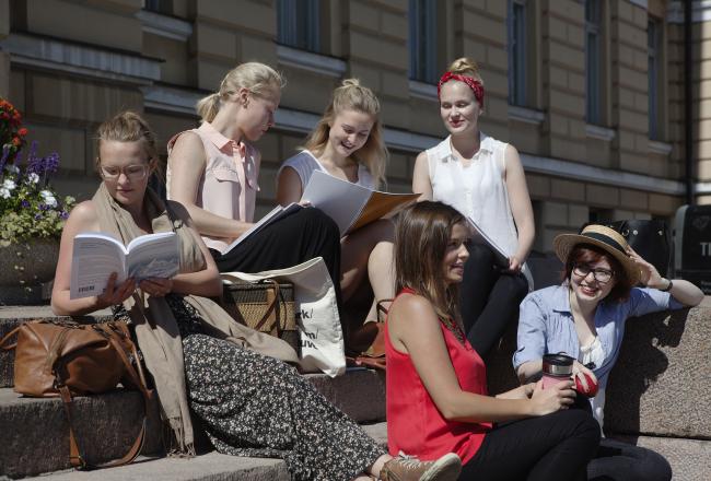 Kuvituskuva, opiskelijat istuvat rappusilla lukemassa