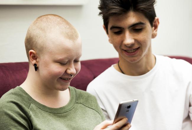 Youngsters from the international youth exchange looking at a smartphone 