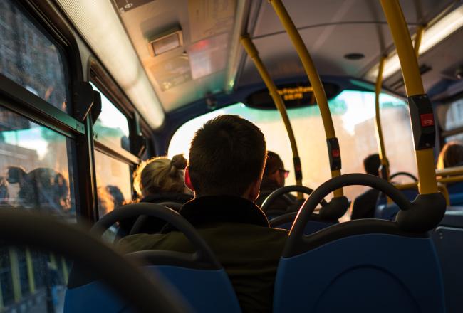 Ihmisiä bussissa. Kuvituskuva.