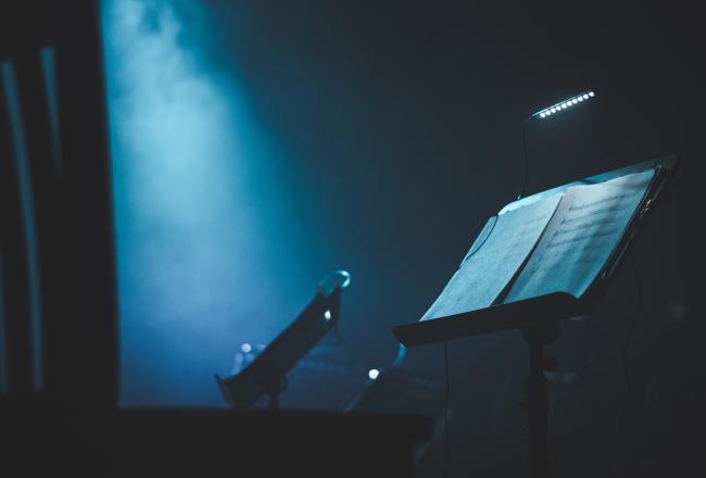 Young Opera Makers Programme -hanke, kuvituskuva. Kuvassa Nuottiteline sinisellä taustalla.