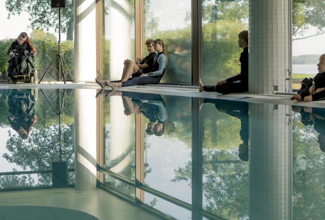 Future DiverCities -hanke. Kuvassa Maija Mustonen Kaaos Companyn Pond -esityksestä. Ihmisiä uima-altaan reunoilla.