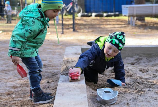 Lapset leikkivät hiekkalaatikolla
