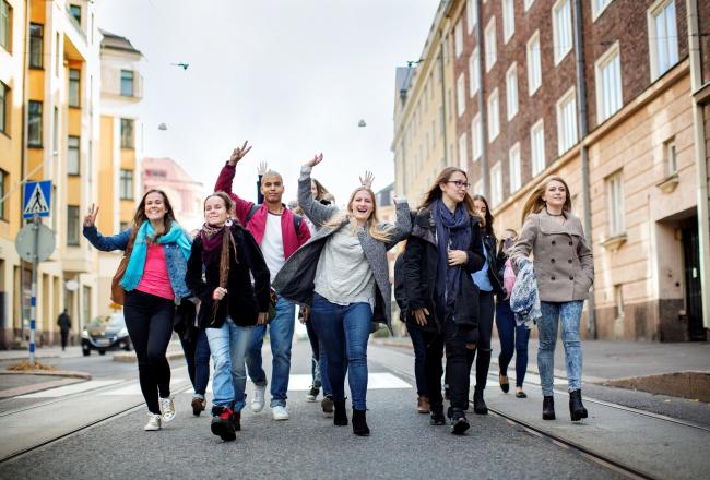 Group of happy students walking down a city street