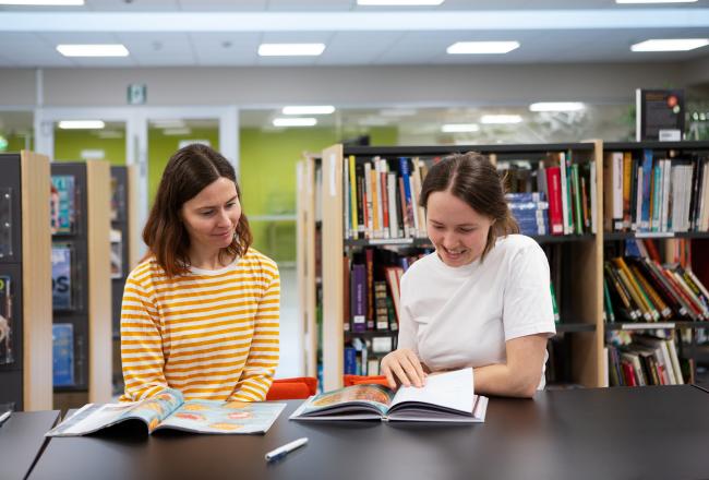 Två studenter vid ett bord i studentbiblioteket på en yrkesskola.