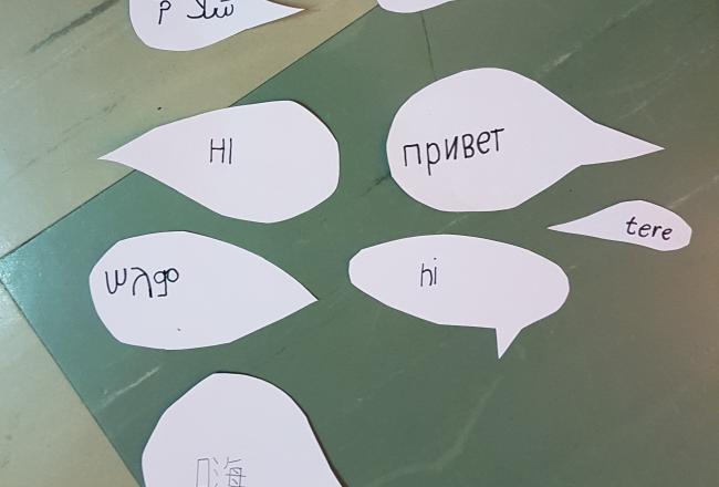 Eri kielisiä sanoja paperista leikatuissa puhekuplissa