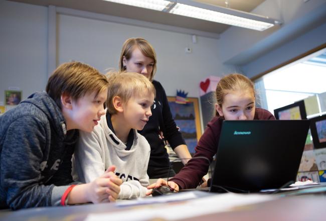 Opettaja ja oppilaat tietokoneella
