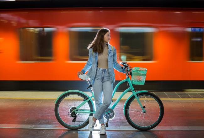 Kvinna med en cykel på en tunnelbanestation