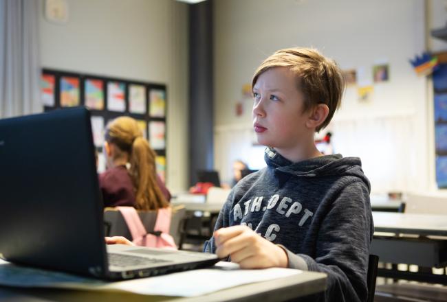 Poika miettii tietokoneen ääressä