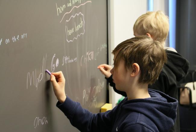 Oppilaat kirjoittavat taululle sanoja kielten tunnilla
