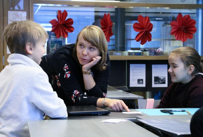 opettaja ja oppilaita alakoulun luokassa