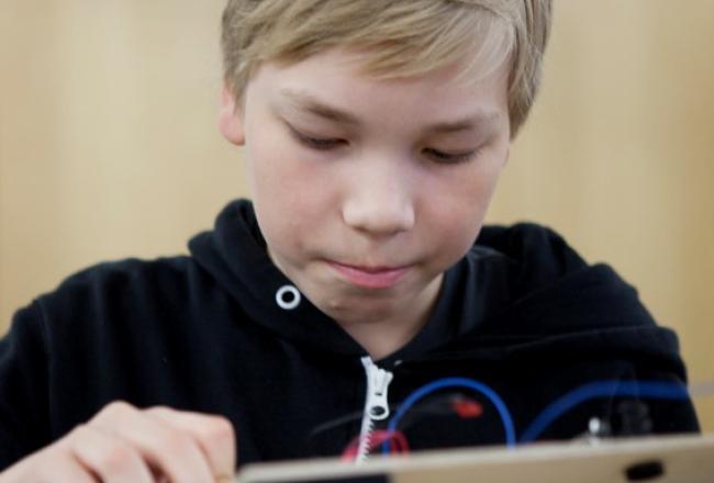 Oppilas työskentelee elektroniikan työtehtävän parissa.
