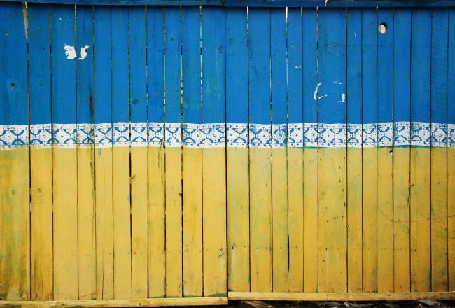 Siniseksi ja keltaiseksi maalattu lauta-aita