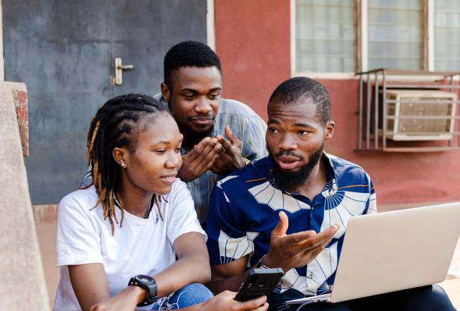 Two men and a women working together on a laptop
