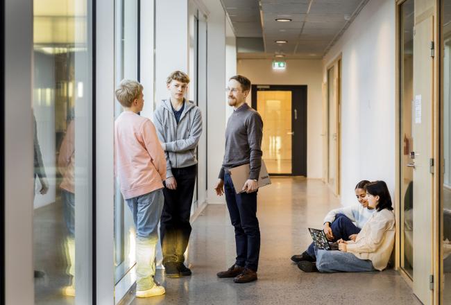 Opettaja ja oppilaita koulun käytävällä