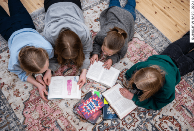 Barn som ligger på golvet och läser