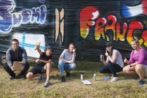Kansainvälisen nuorisotapaamisen nuoria graffitia maalaamassa