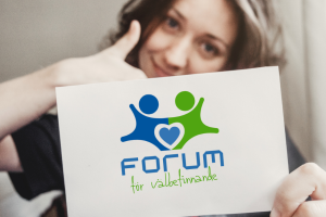 En person ger tummen upp samtidigt som hen håller upp en skylt med texten: Forum för välbefinnande