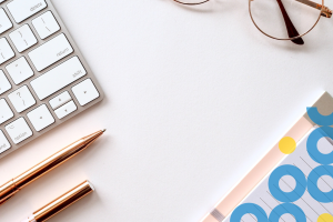 keboard, pen, eyeglasses and notebook on table