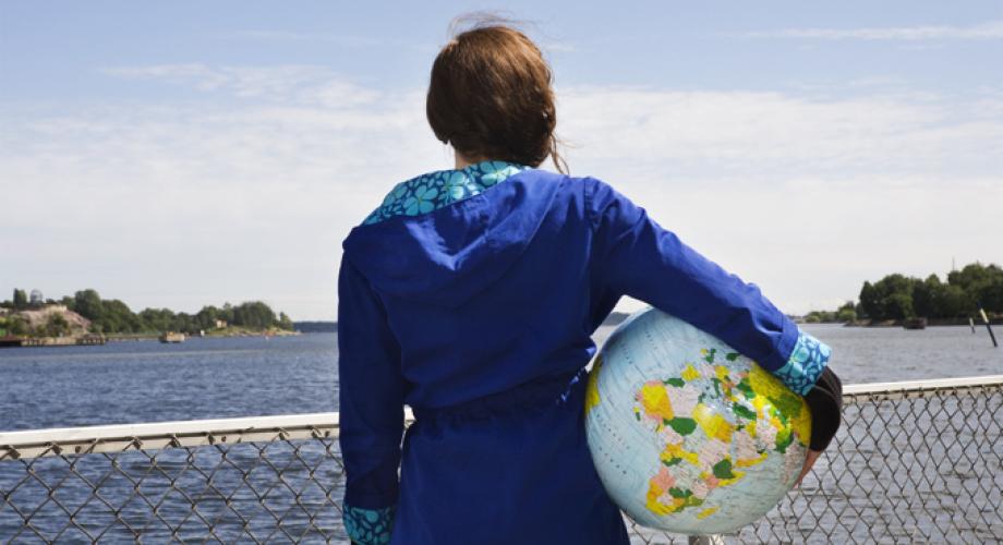 Kuvituskuva, tyttö jolla maapallo kainalossa