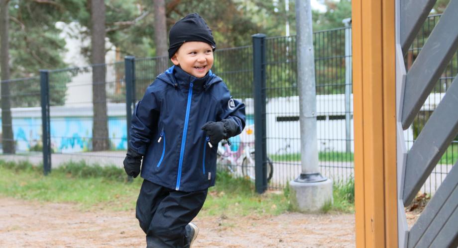 Kuvituskuva, lapsi juoksee päiväkodin pihalla
