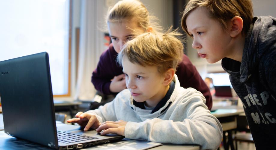 Kuvituskuva, kolme lasta tietokoneen ääressä