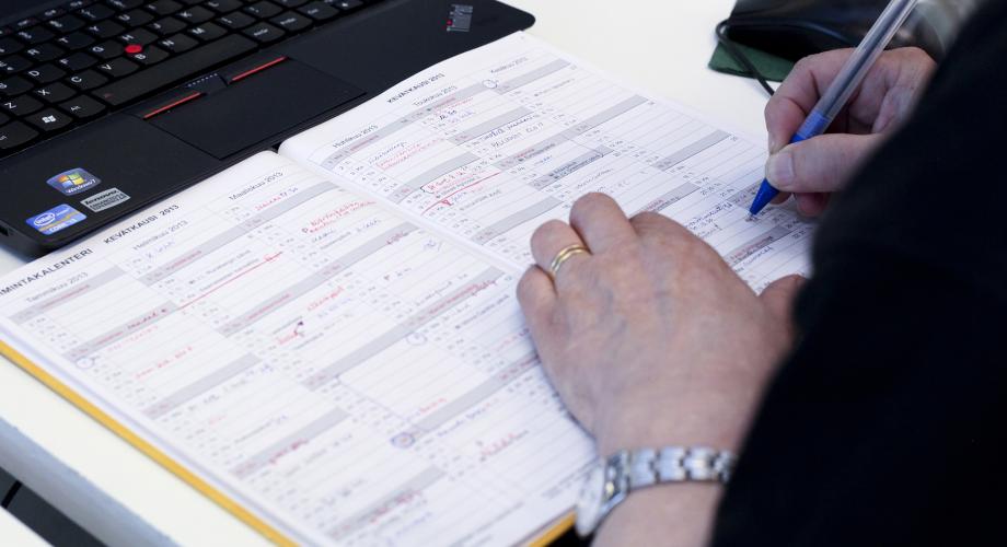 Opettaja kirjoittaa kalenteriin