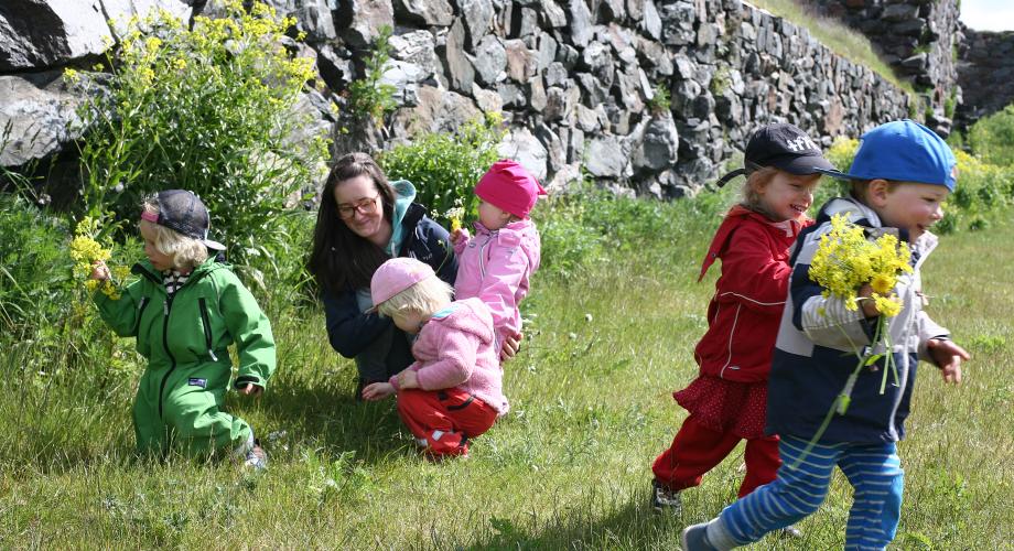 Kuvituskuva, lapset keräävät kukkia