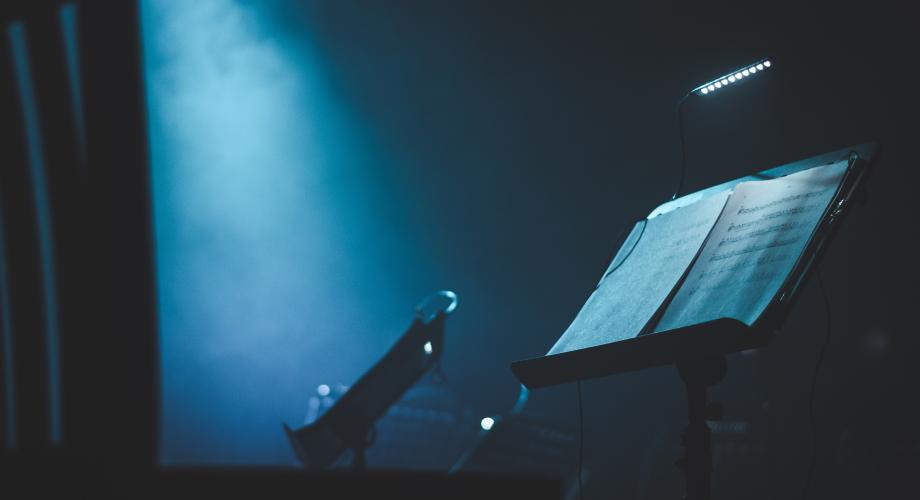 Young Opera Makers Programme -hanke, kuvituskuva. Kuvassa Nuottiteline sinisellä taustalla.