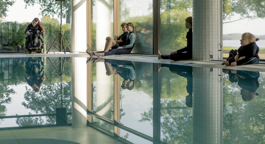 Future DiverCities -hanke. Kuvassa Maija Mustonen Kaaos Companyn Pond -esityksestä. Ihmisiä uima-altaan reunoilla.