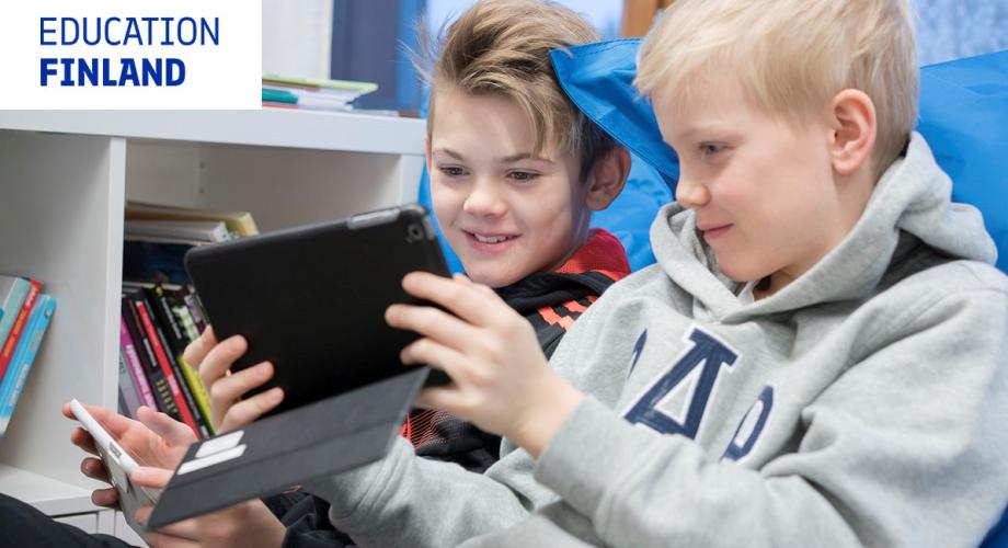 Kaksi poikaa katsoo tablettia koulussa