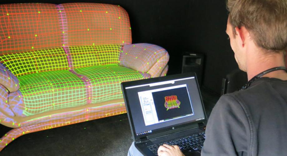 Opiskelija tekee digitaalista kuviointia sohvaan tietokoneella.