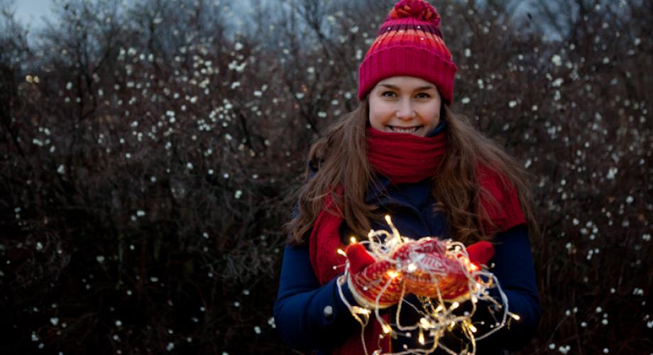 Myssypäinen tyttö käsissään punaiset lapaset ja kaamosvalot