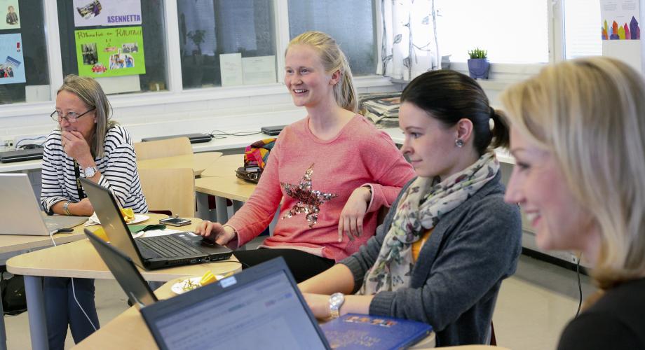 Neljä naisopettajaa pitää kokousta luokassa