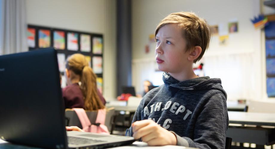 Poika miettii tietokoneen ääressä