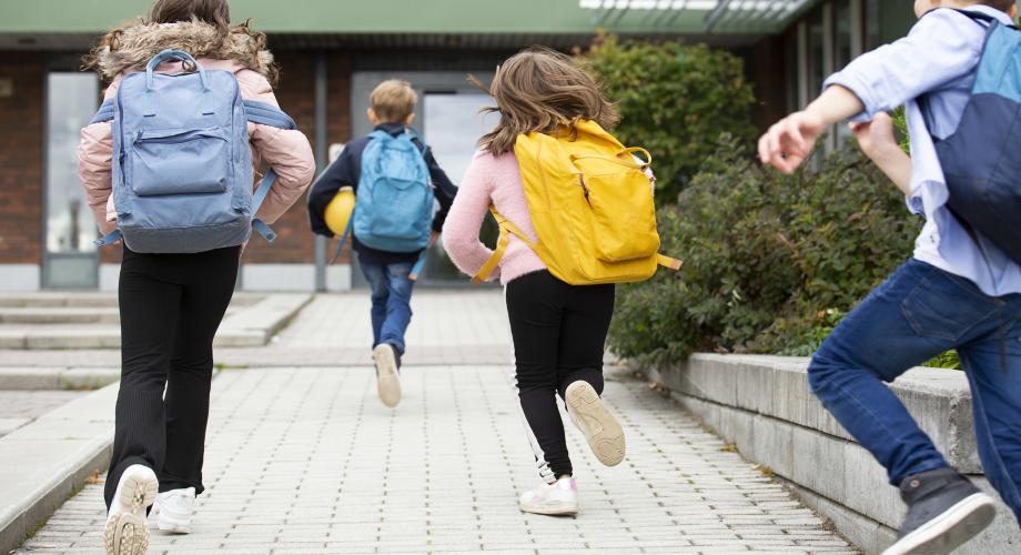 Lapset juoksevat kouluun