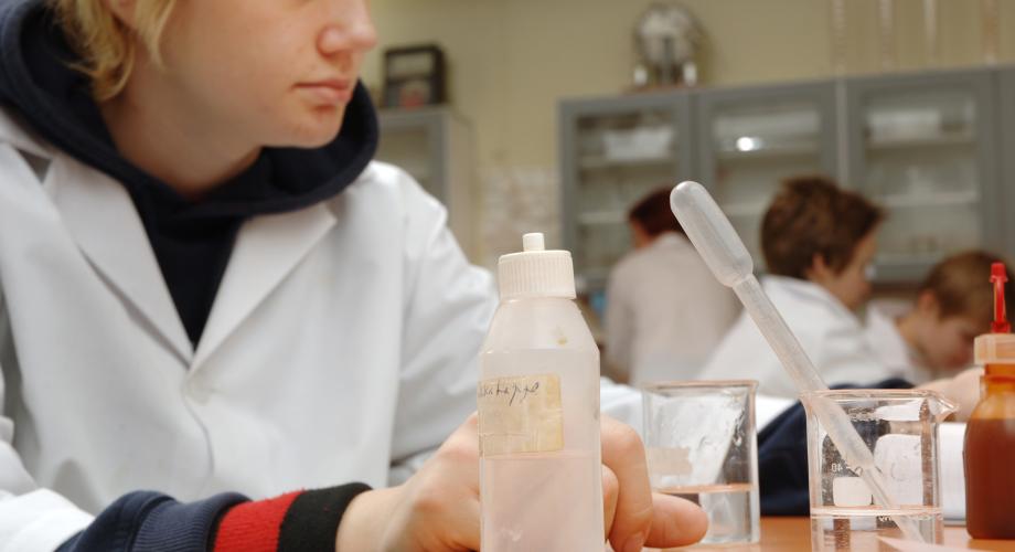 Oppilas kemian tunnilla koeputkien ja pipettien parissa työskentelemässä