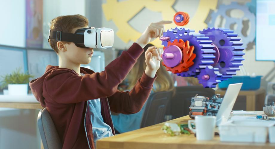 Kuvituskuva. Poika mallintaa virtuaalilaseilla vaihdejärjestelmää.