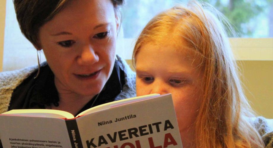 En kvinna läser en bok för ett barn. Bokens namn är noll vänner.