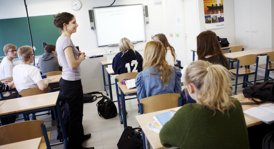 Opettaja ja yläkoulun oppilaita luokassa.