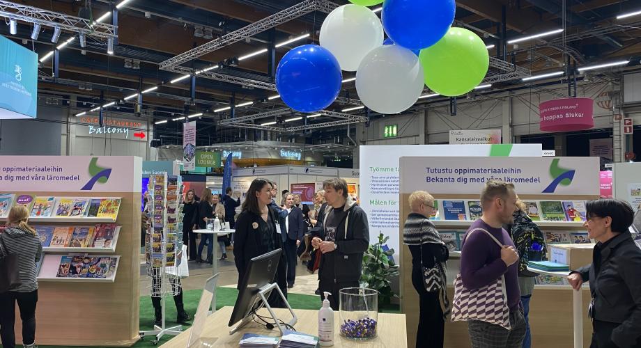Opetushallituksen Educa-messuosasto Educa-messuilla 2023. Osaston visuaalinen ilme pohjautuu Opetushallituksen tunnusväreihin siniseen ja vihreään.
