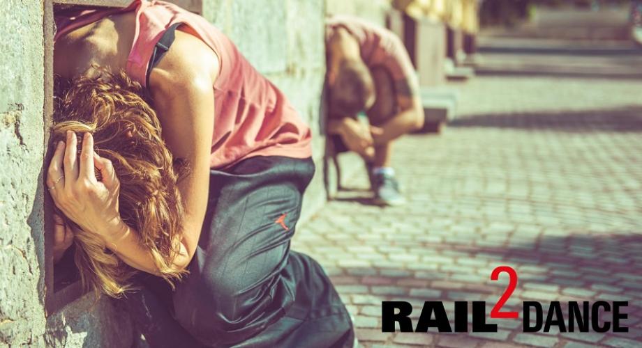 Kaksi tanssijaa kyyryssä aurinkoisella vaalealla kujalla, edessä teksti Rail2Dance